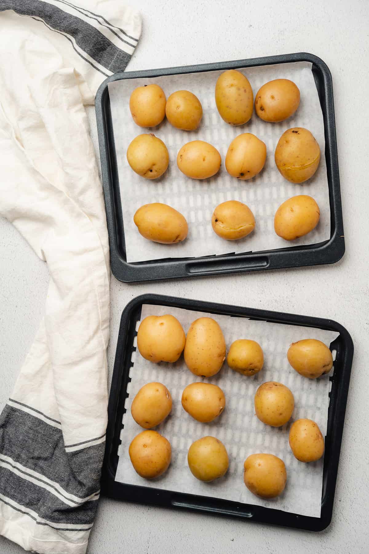 potatoes on air fryer trays with parchment paper
