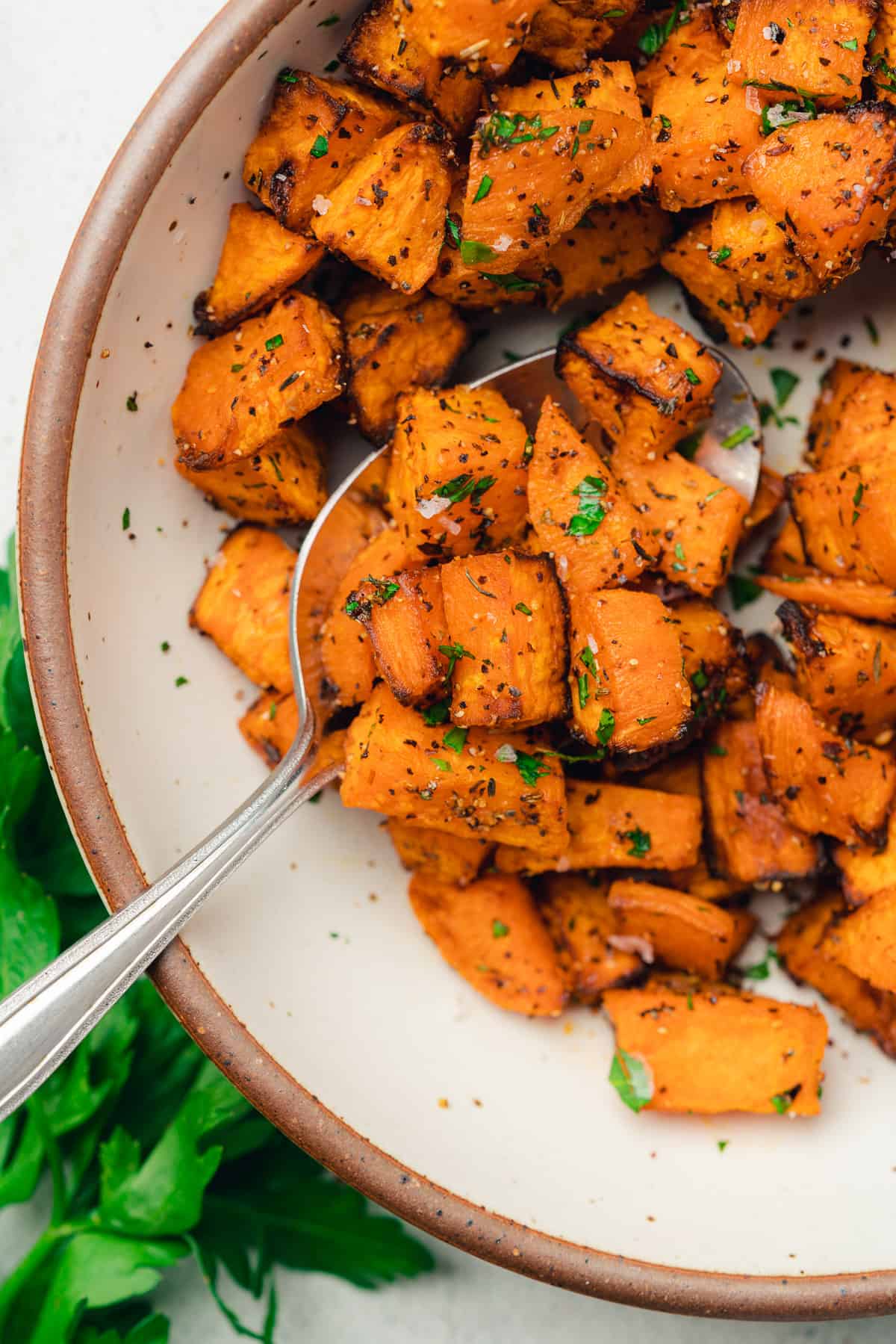 spoonful of air fryer sweet potato cubes in a ceramic bowl