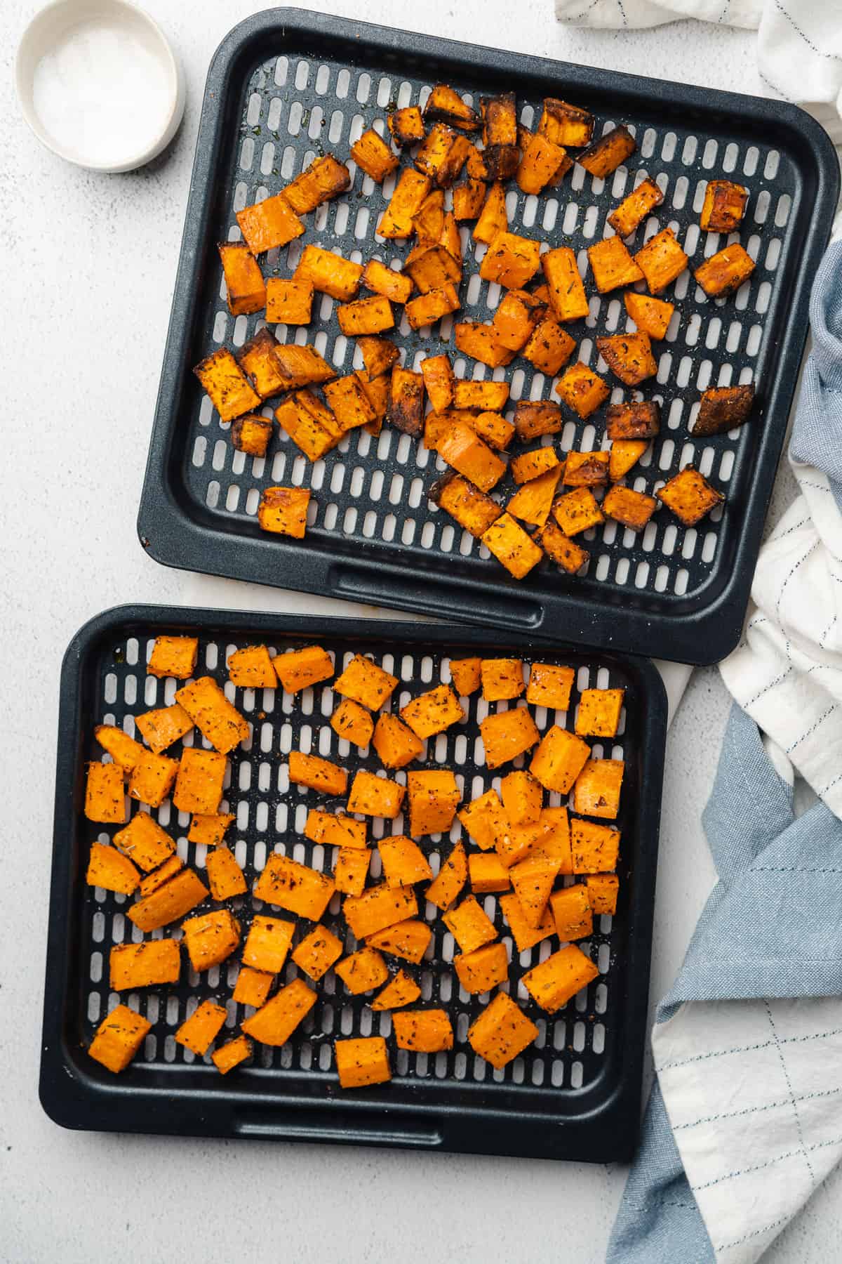 cooked sweet potato cubes on air fryer trays