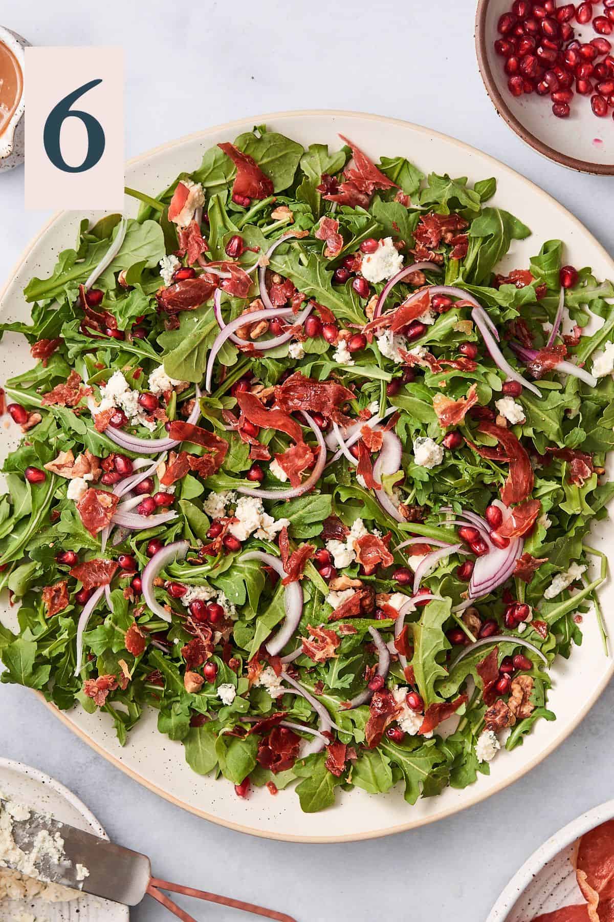 arugula salad with prosciutto, red onion, pomegranate, walnuts, and blue cheese.