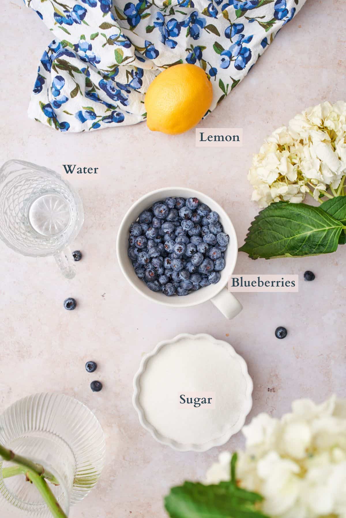 blueberry simple syrup ingredients laid out in bowls and labeled to denote each ingredient. 
