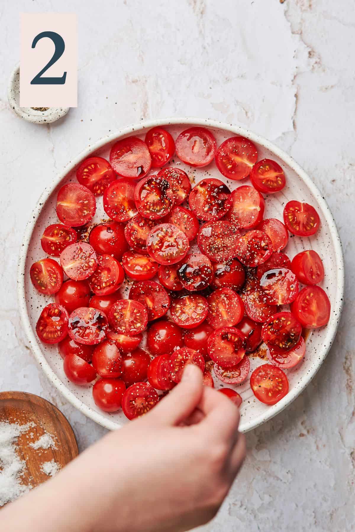 Halved cherry tomatoes with salt, pepper, and balsamic glaze on top.