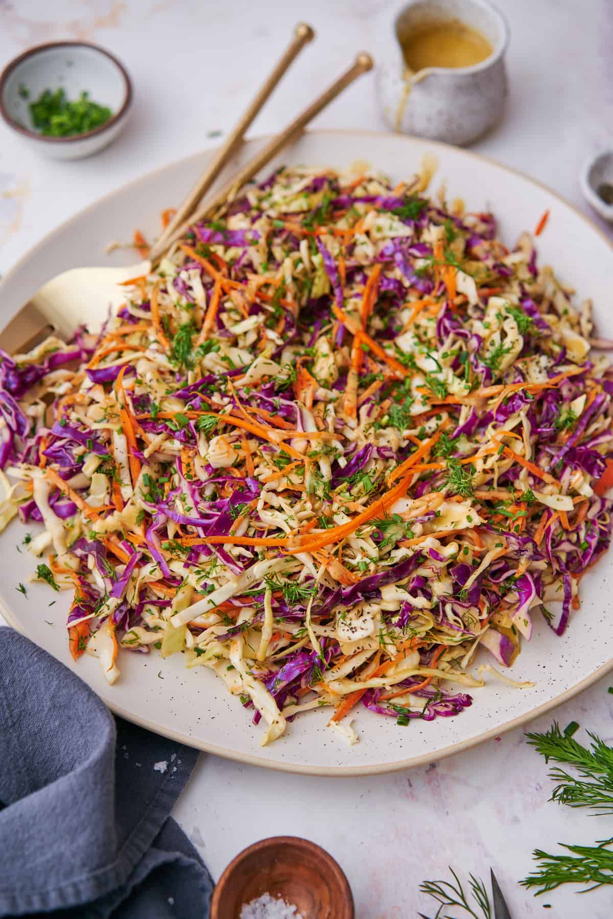 large and colorful cabbage and carrot salad on a round ceramic serving platter. 