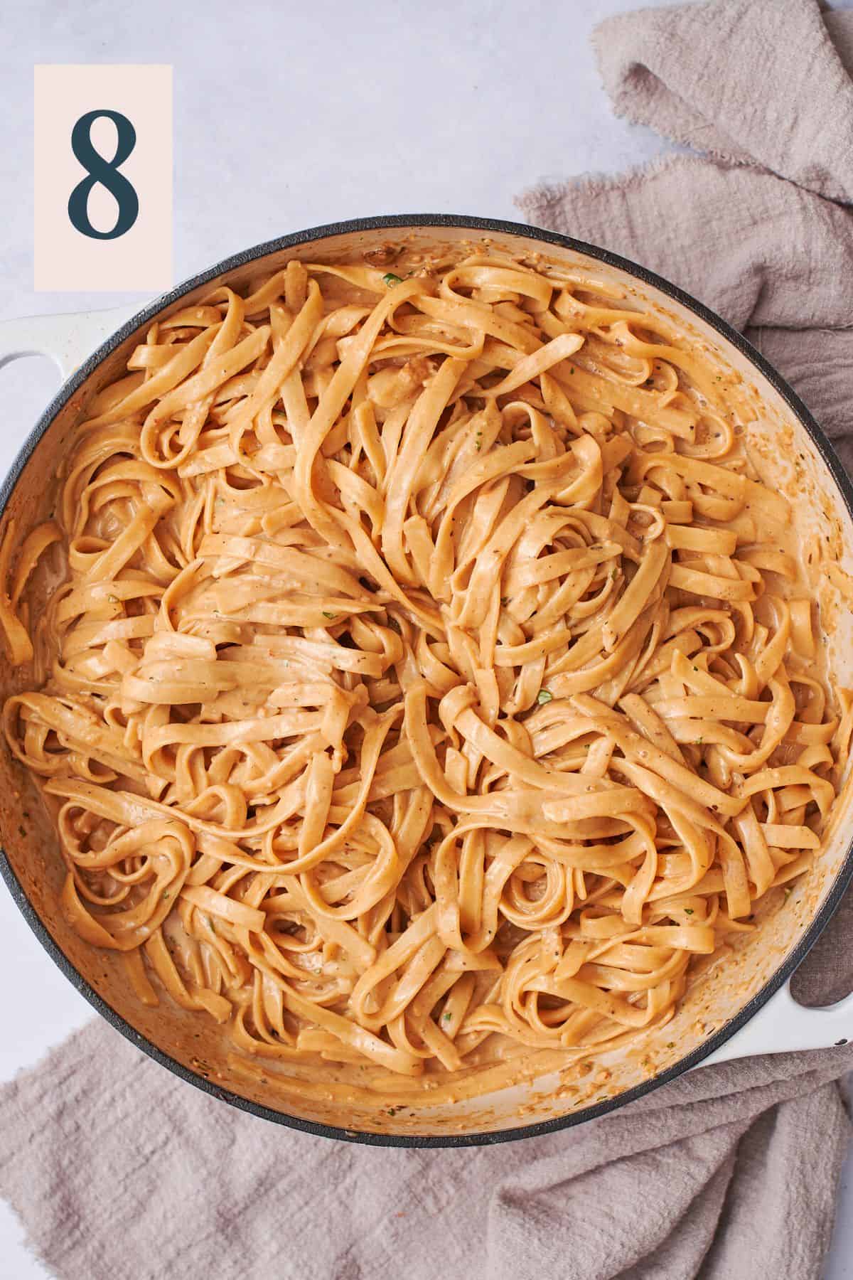 cooked pasta tossed in creamy pasta sauce in a skillet. 