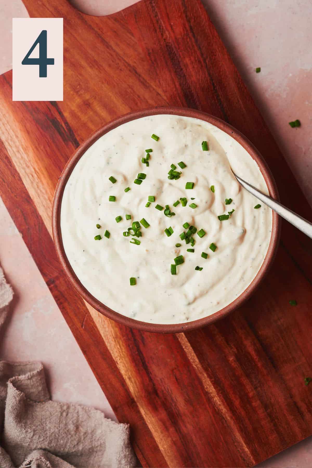 horseradish dipping sauce in a bowl topepd with chives. 