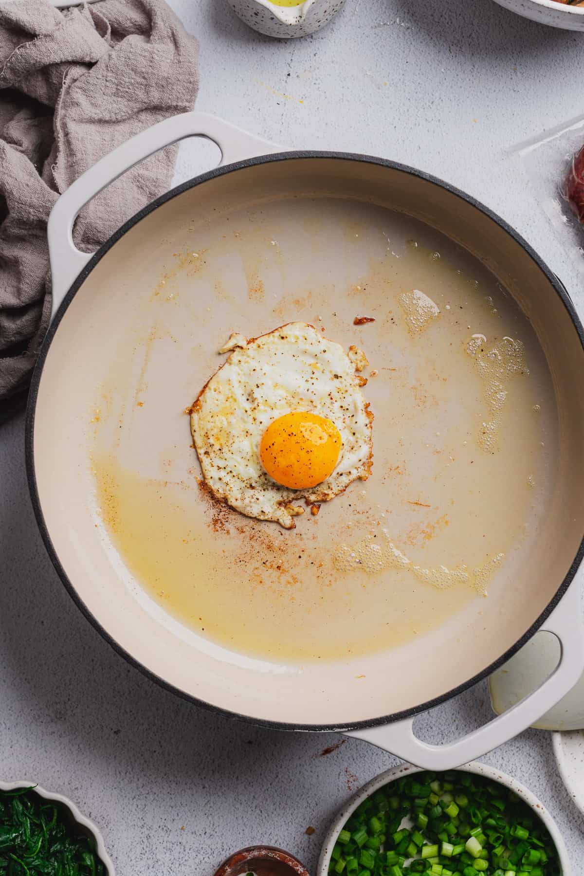 fried egg cooked in butter in an enameled cast iron