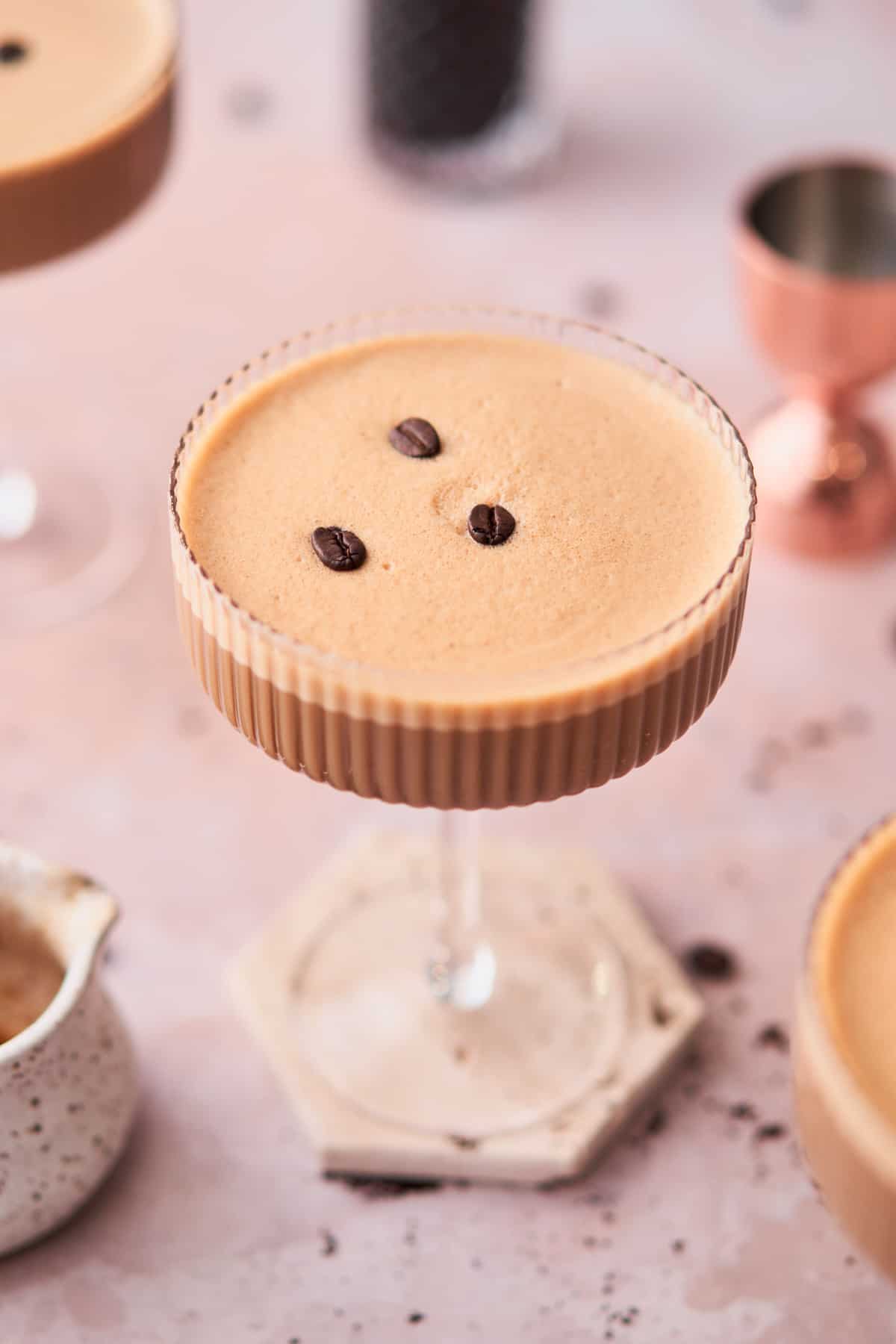 creamy espresso martini with Baileys and 3 espresso beans on top on the creamy foam top. 