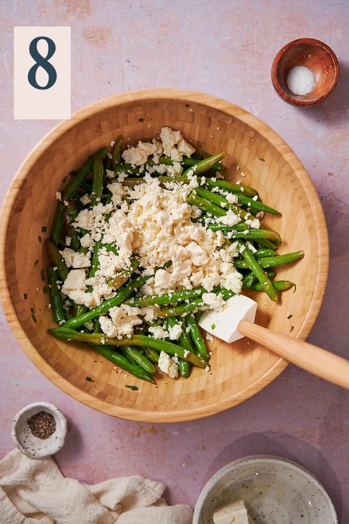 green beans in a large bowl with feta crumbled over top. 
