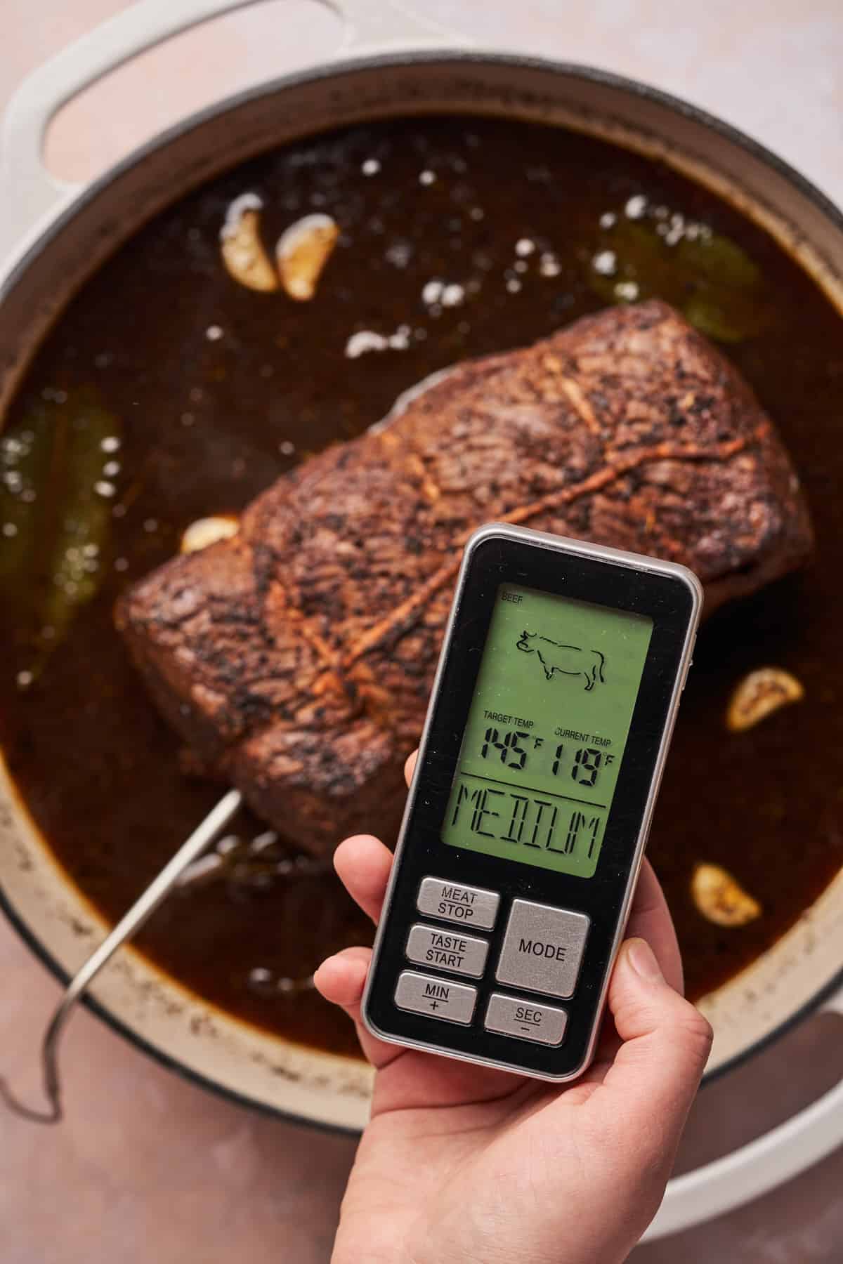 beef roast with a meat thermometer showing the internal temperature at 118°F.