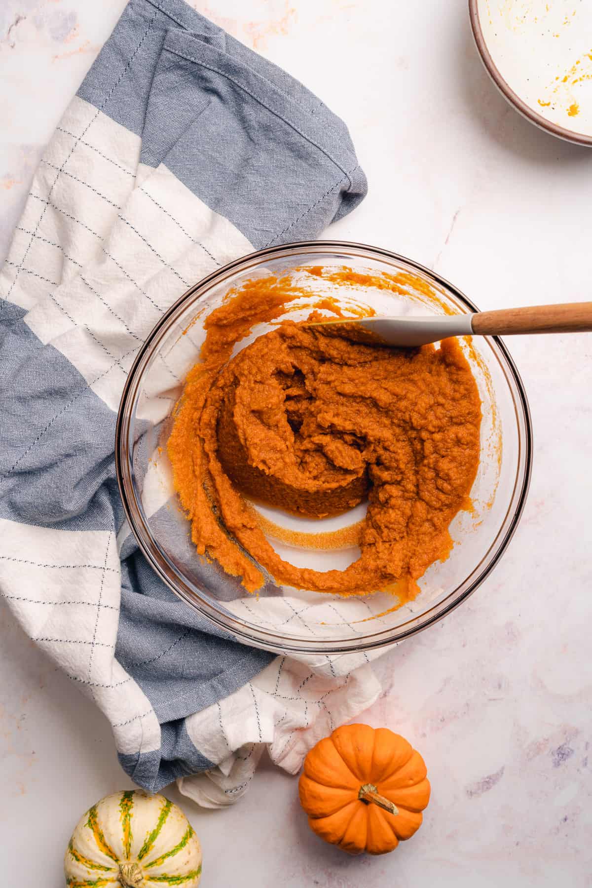 mixing the pumpkin puree together in a large mixing bowl with a rubber spatula
