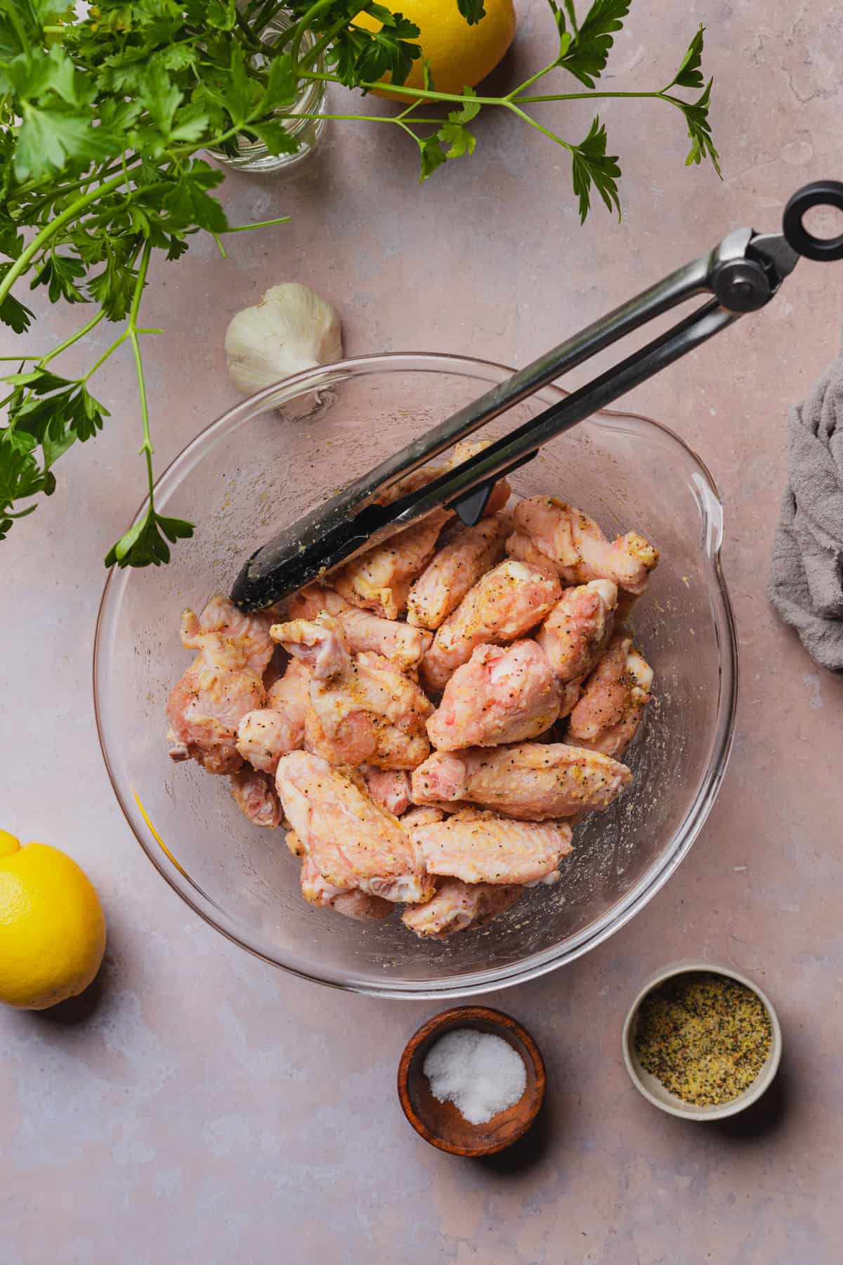 tossing chicken wings in a large mixing bowl with oil, and lemon pepper seasoning blend.