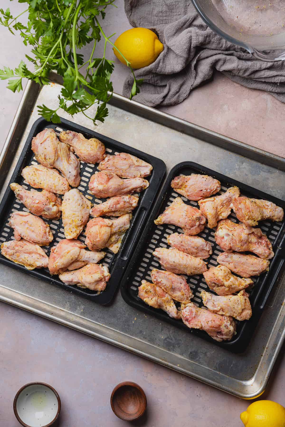 chicken wings on air fryer trays on a baking tray