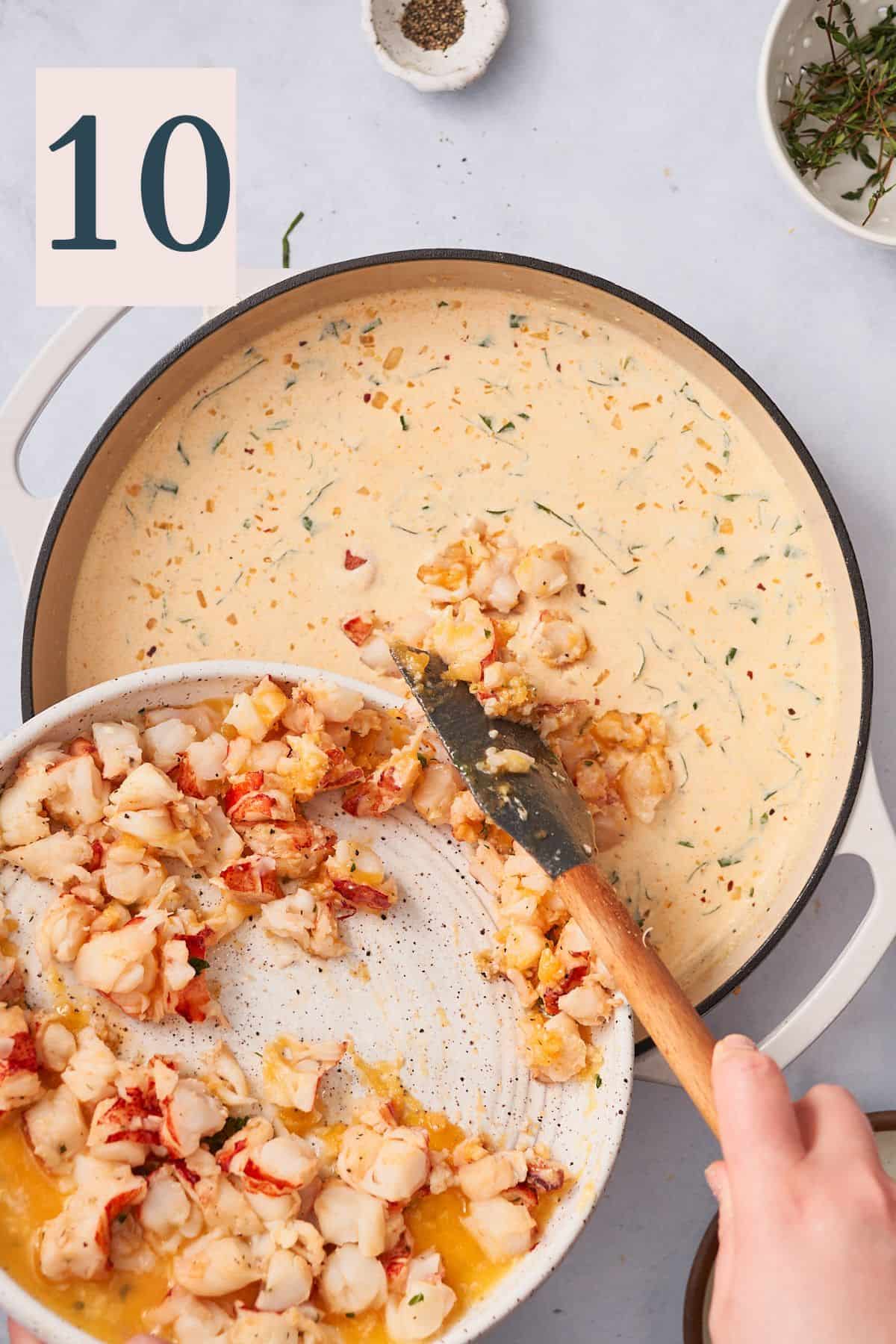 hand pouring chunks of lobster meat into a cream sauce in a large skillet. 