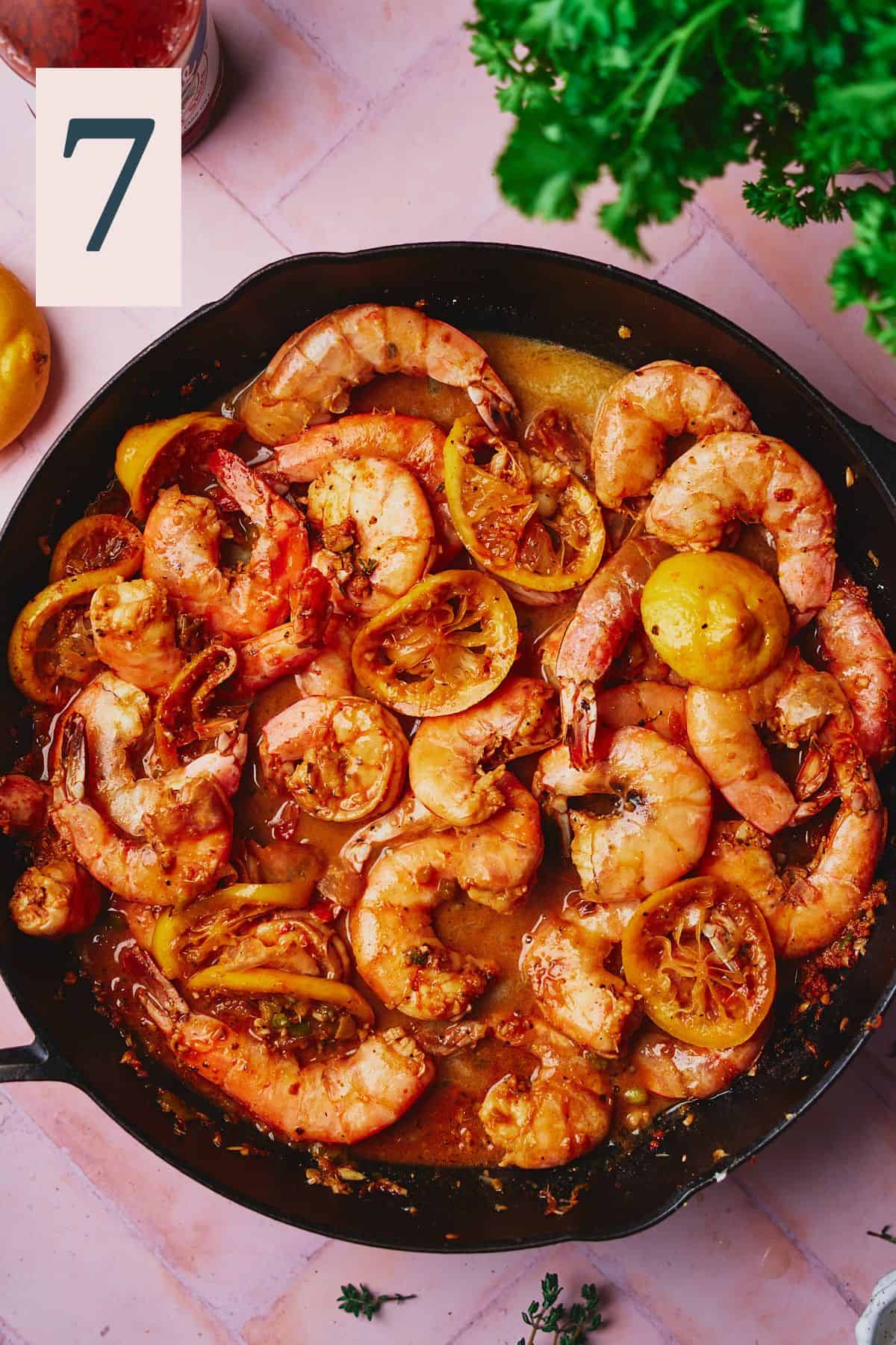 Cooked New Orleans shrimp in a skillet with a buttery and lemony sauce. 