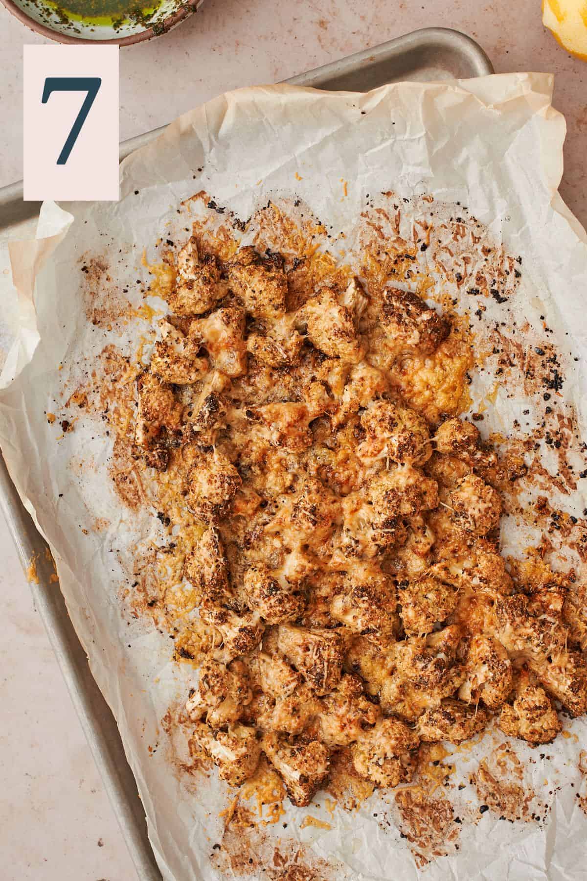 crispy cauliflower with parmesan on a baking sheet lined with parchment paper. 