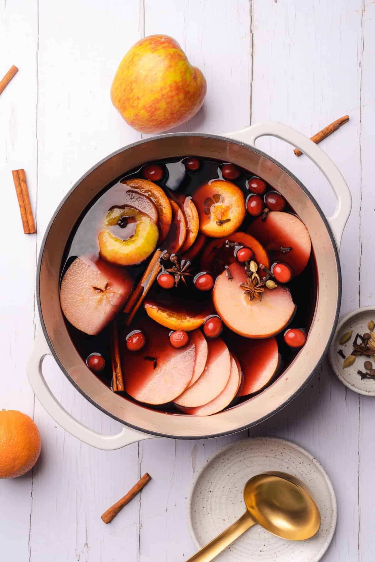 making mulled wine in a dutch oven with fruit and warming spices 