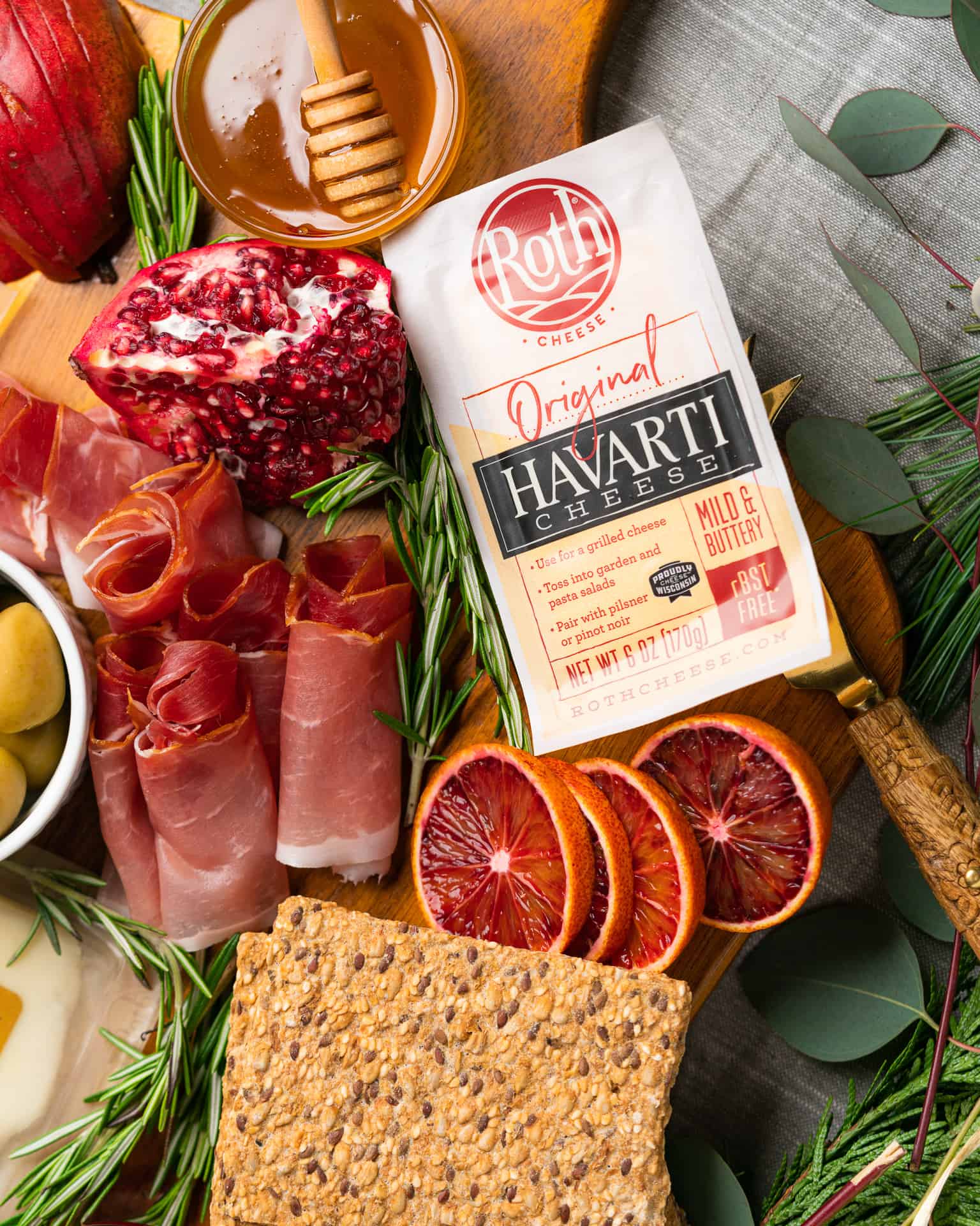 Roth Cheese Havarti Cheese sitting on charcuterie board with blood oranges and various meats