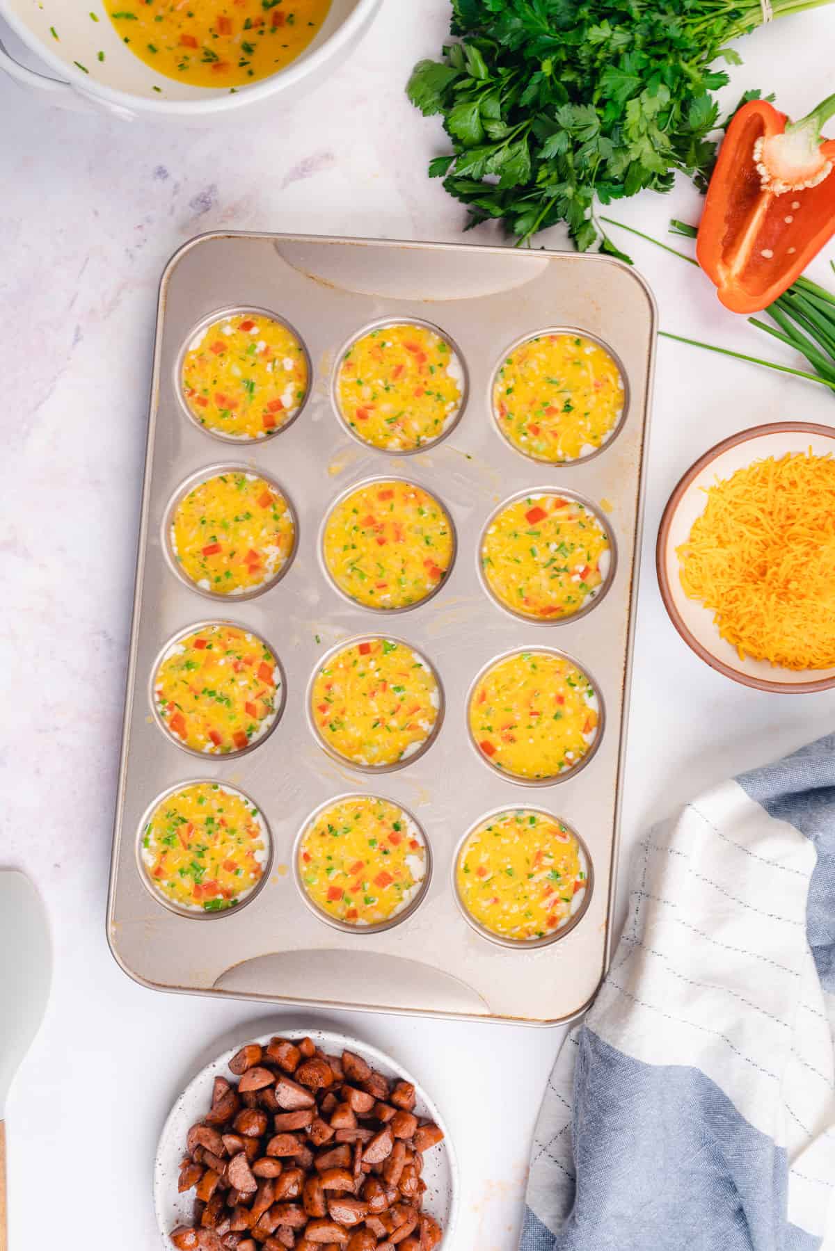 egg muffins in a muffin tin with bell peppers and herbs