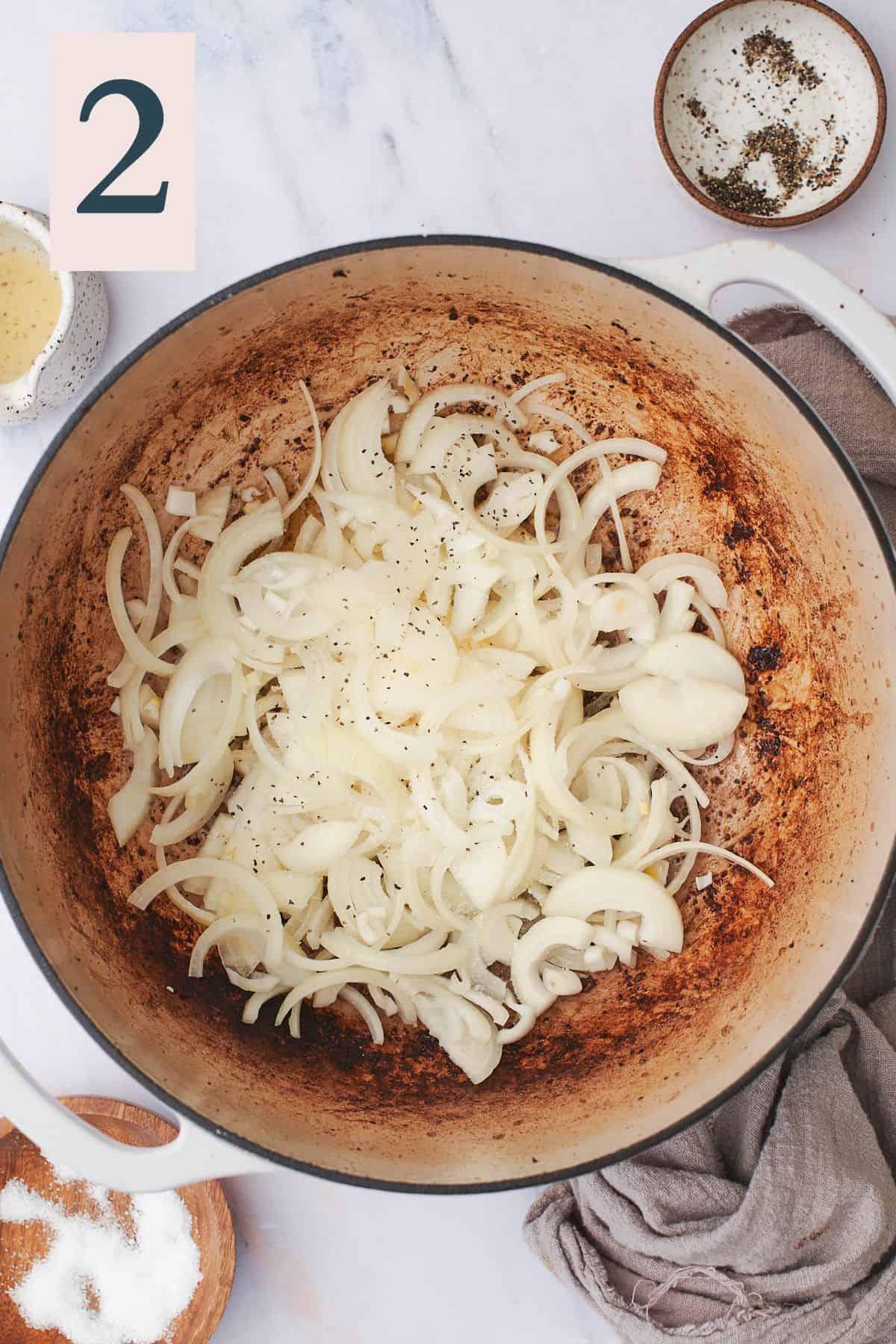yellow onions sliced thinly in the bottom of a dutch oven. 